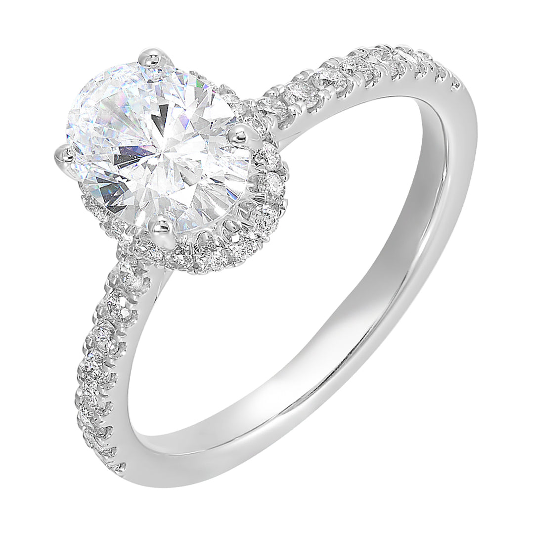 This stunning engagement ring features an oval solitare diamond, accented by pave set round diamonds on shank and a hidden halo.